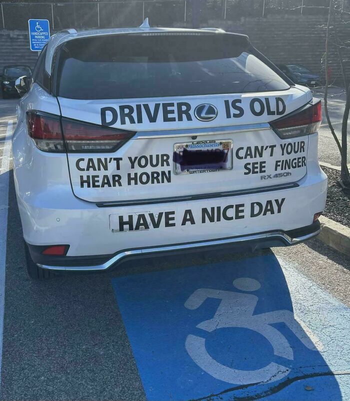 A hilariously confusing sign design on a white car reads: Driver is Old. Can't Your Hear Horn. Can't Your See Finger.