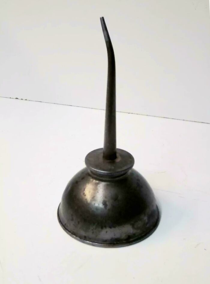 Old metal oil can with a long narrow spout, a nostalgic item recognizable from vintage tool collections.