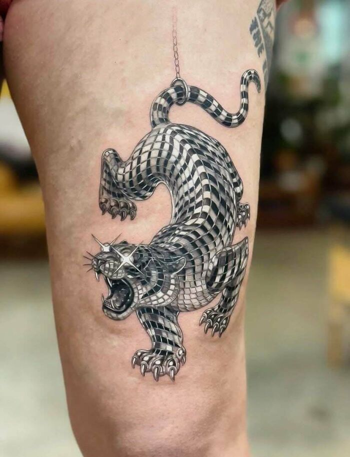 Stunning tattoos: A striking black and white tiger tattoo with a mosaic pattern on a person's leg.