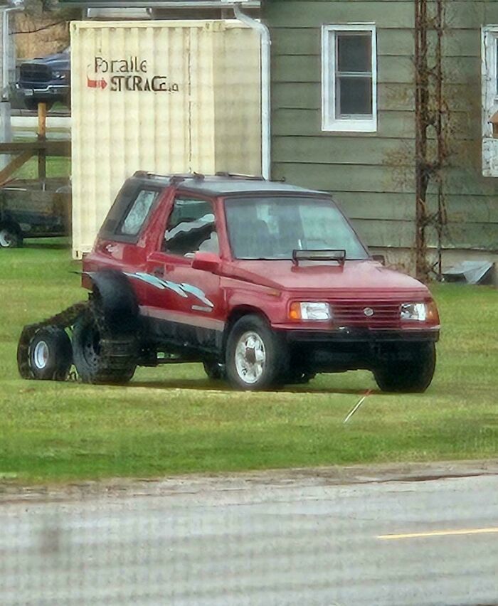 A red SUV modified with tank treads in the back, a clear example of DiWHY attempts.