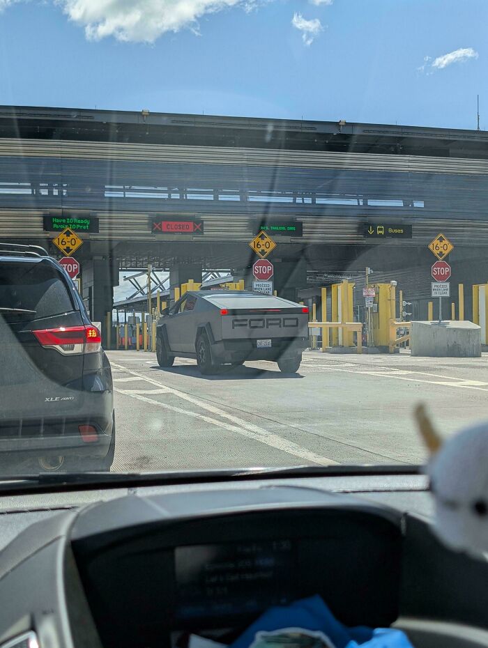 A Tesla Cybertruck with a DIY "FORD" sticker on its tailgate, attempting to pass through a checkpoint. #DiWHY