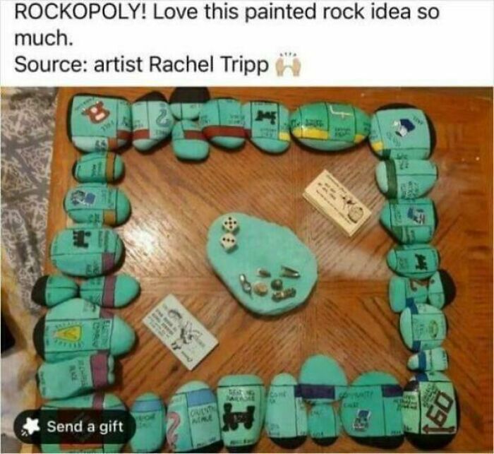 A DiWHY Monopoly game board made from painted rocks with game pieces and dice.