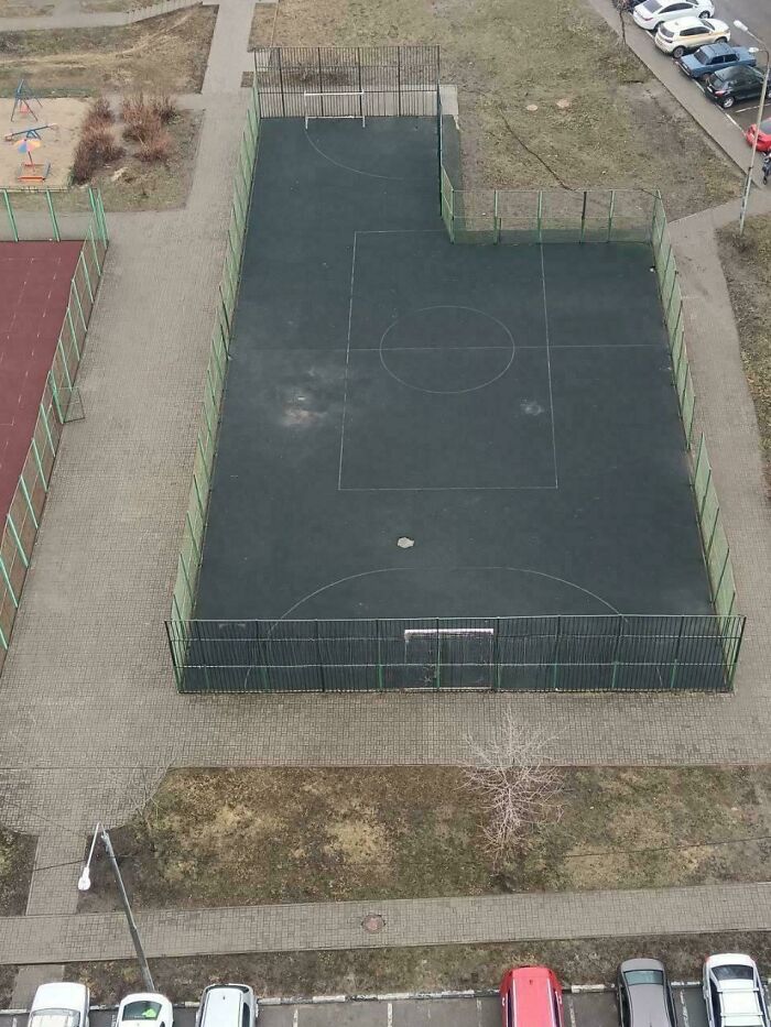 Aerial view of a quirky, L-shaped sports court next to a red court and parking lot. DiWHY design.