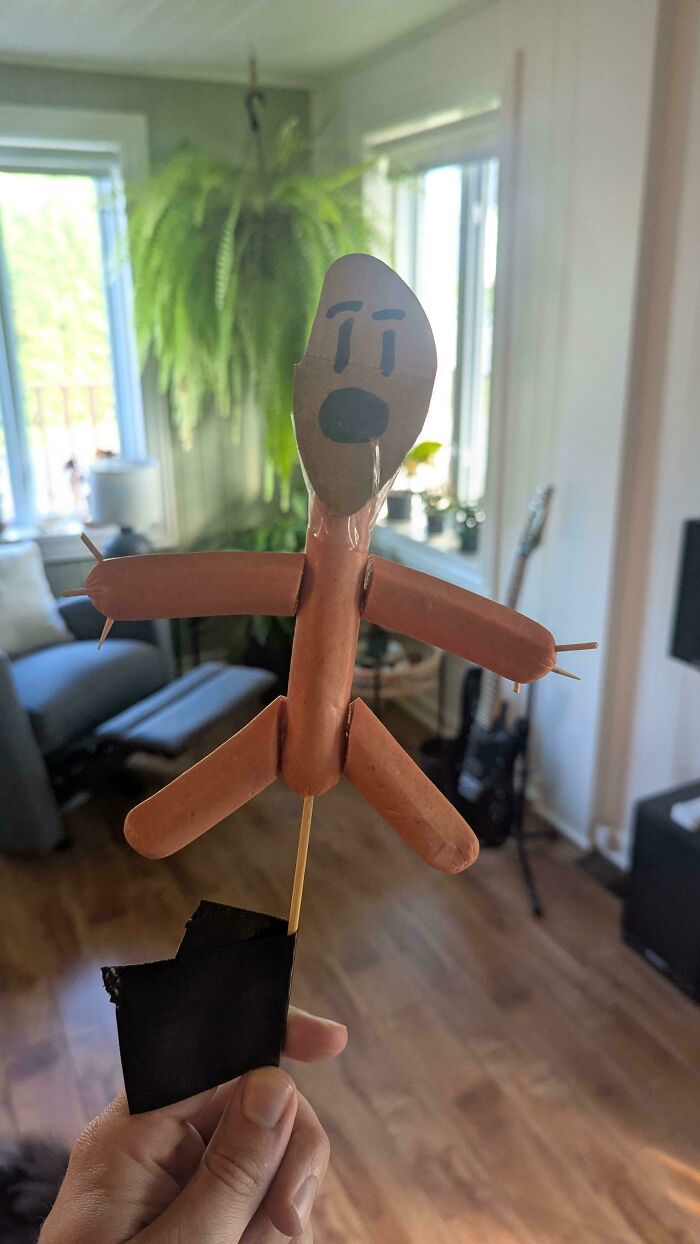 A DiWHY project: a figure made from hot dogs and toothpicks, with a worried cardboard face.