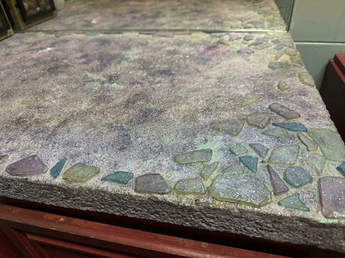 A glittery, purple-hued DiWHY countertop with embedded iridescent sea glass pieces, showcasing a DIY project attempt.