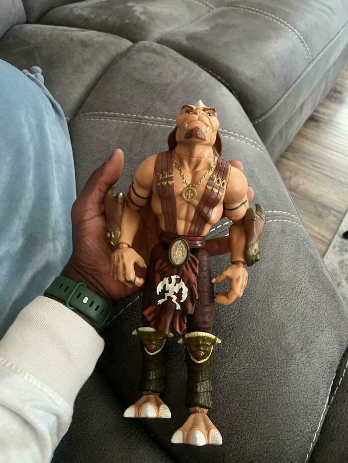 A hand holding a classic '90s kid action figure, evoking nostalgic memes and childhood memories.