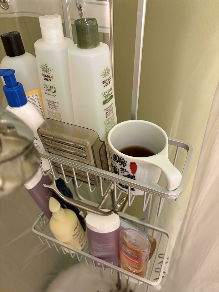 A shower caddy filled with Trader Joe's Tea Tree Tingle products, other toiletries, and a mug of coffee. Great for dads.