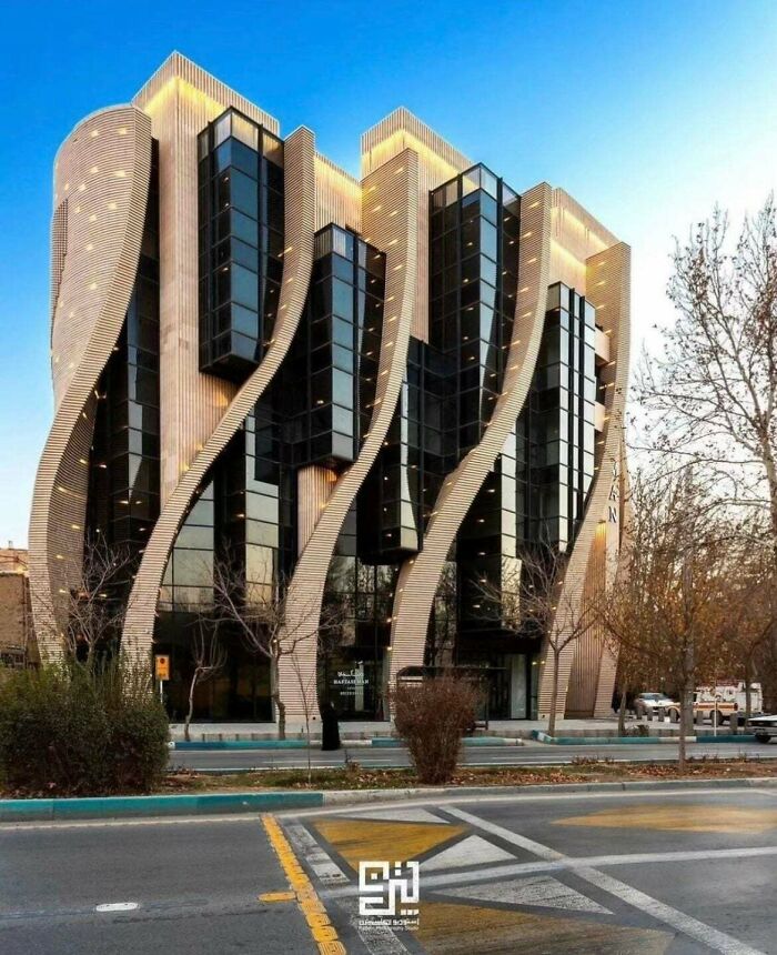 Striking architecture of a building with wavy wooden facades and dark glass panels, captivating architecture lovers.