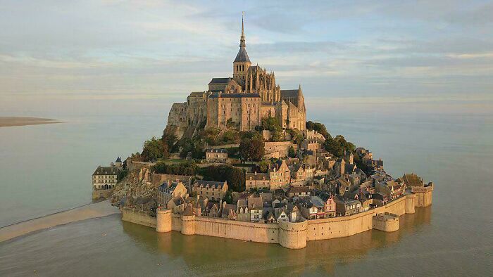 Aerial view of Mont Saint-Michel, a magnificent island monastery and village surrounded by water. Impressive architecture.