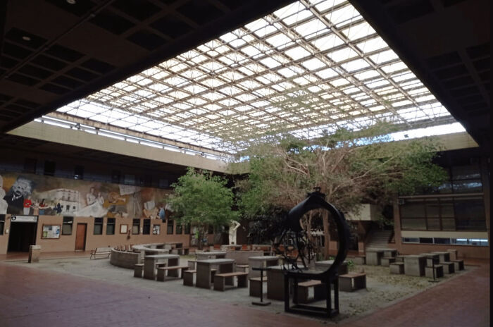 Architecture lovers will admire this building's indoor courtyard with trees, murals, and a grid-patterned skylight.