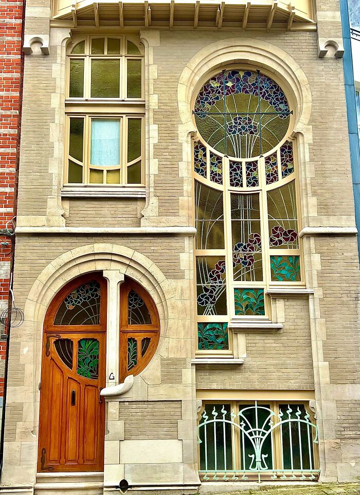 An impressive building with intricate Art Nouveau architecture, featuring colorful stained glass windows and a unique wooden door.