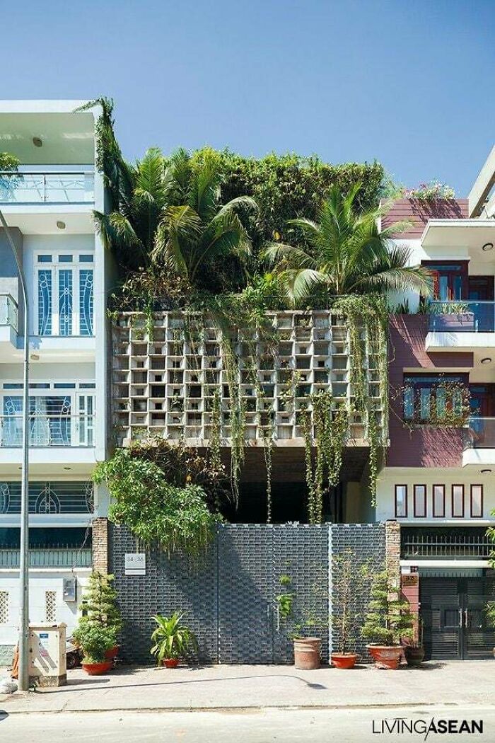 A captivating building featuring a geometric grid facade covered in lush green plants, truly impressive architecture.
