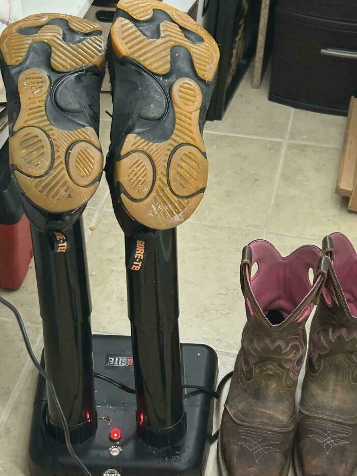 A pair of work shoes drying on a boot dryer next to a pair of cowboy boots with pink interiors. Frugal tips for the economy.