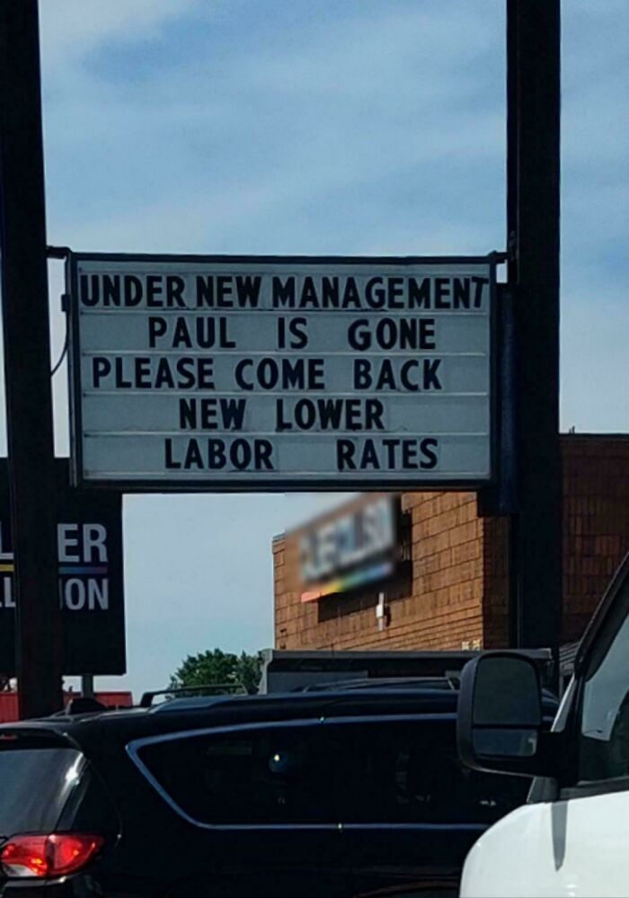 Sign outside a car mechanic shop announcing new management, lower labor rates, and encouraging customers to come back.