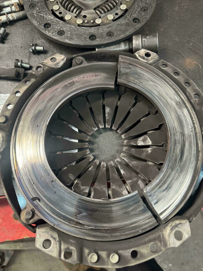 Worn and cracked car clutch pressure plate showing damage mechanics had to document to prove the issue.
