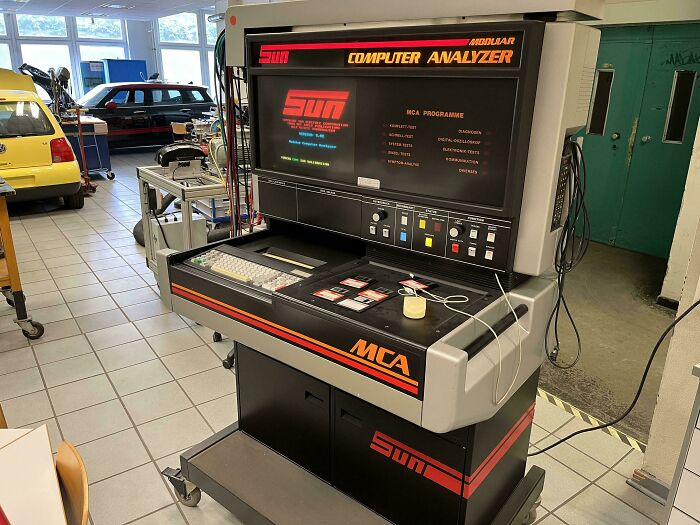Vintage car mechanic computer analyzer in a workshop, showing diagnostic tools used for vehicle repairs and testing.