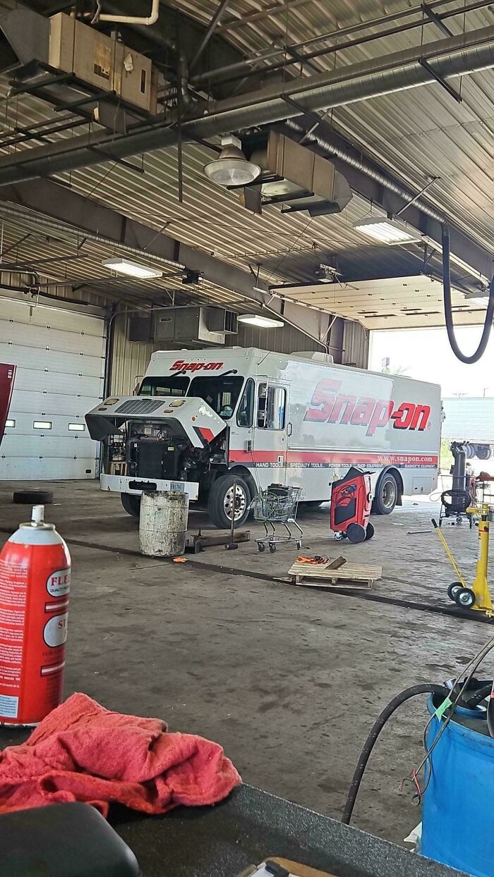 Mechanic shop interior with Snap-on service truck, tools, and equipment showing typical car mechanic workspace details.