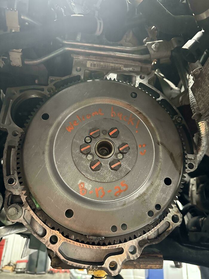 Close-up of a car mechanic's engine part with handwritten notes to document the repair for others to believe.