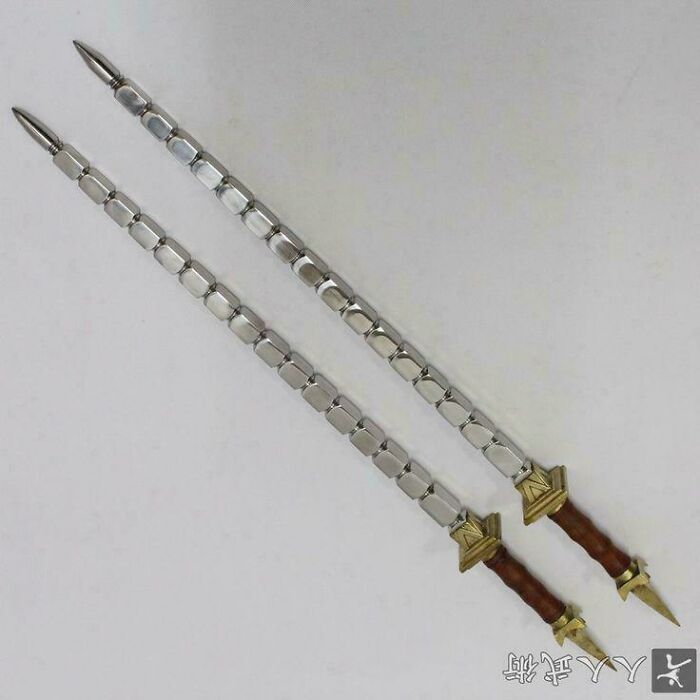 Two long, metallic weapons with pointed ends and decorated handles, reminiscent of Middle Ages armaments.