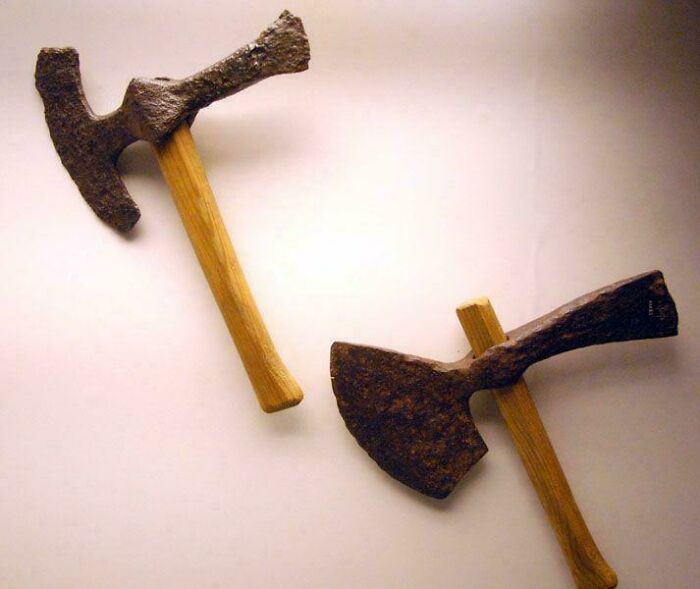 Two ancient axes with wooden handles, artifacts from the fascinating time of the Middle Ages in human history.