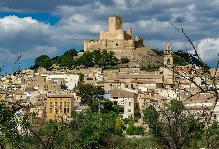 A medieval castle on a hill overlooking a village, showcasing the fascinating Middle Ages in human history.