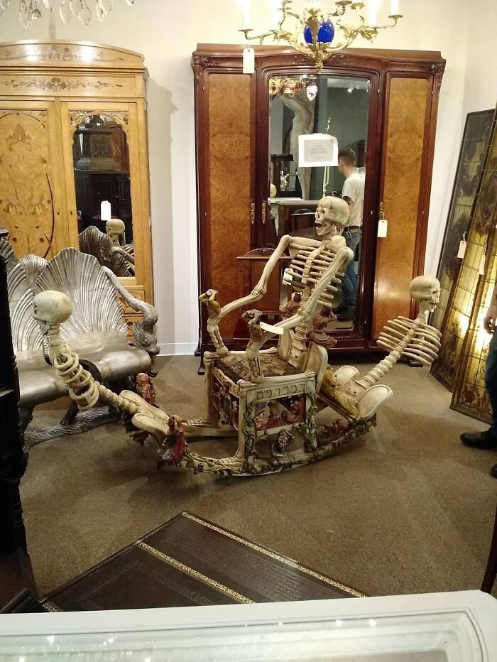 Skeleton-themed rocking chair among antique furniture in a showroom, a ridiculous piece of furniture that surprises people online.