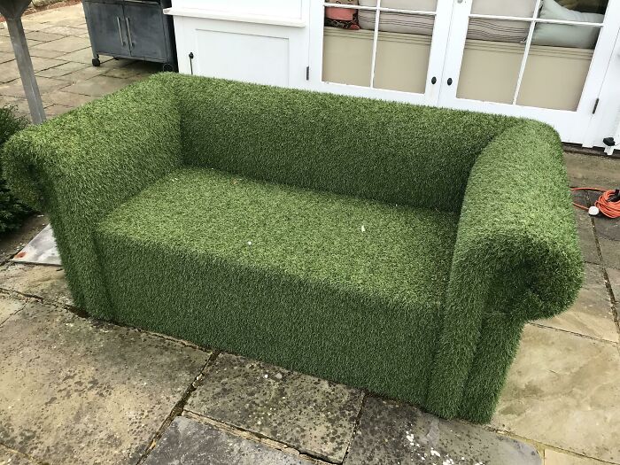 Outdoor sofa covered entirely in artificial grass, a ridiculous piece of furniture spotted and shared online.