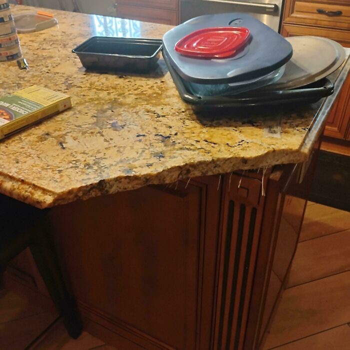 Kitchen countertop with damaged edge showing entitlement of delusional family members in a home setting.