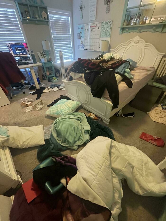 Messy bedroom with clothes, blankets, and pillows scattered on the floor showing entitled family members' disorganized space.