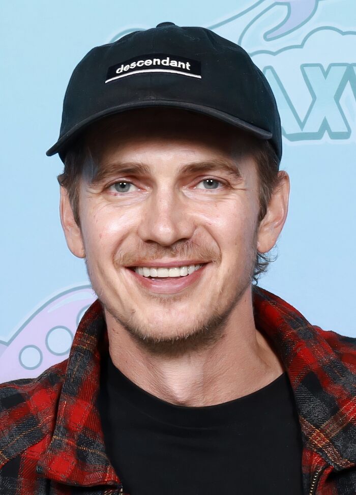 Smiling man wearing a black descendant cap and red plaid shirt, one of the iconic actors who dominated Hollywood then vanished.