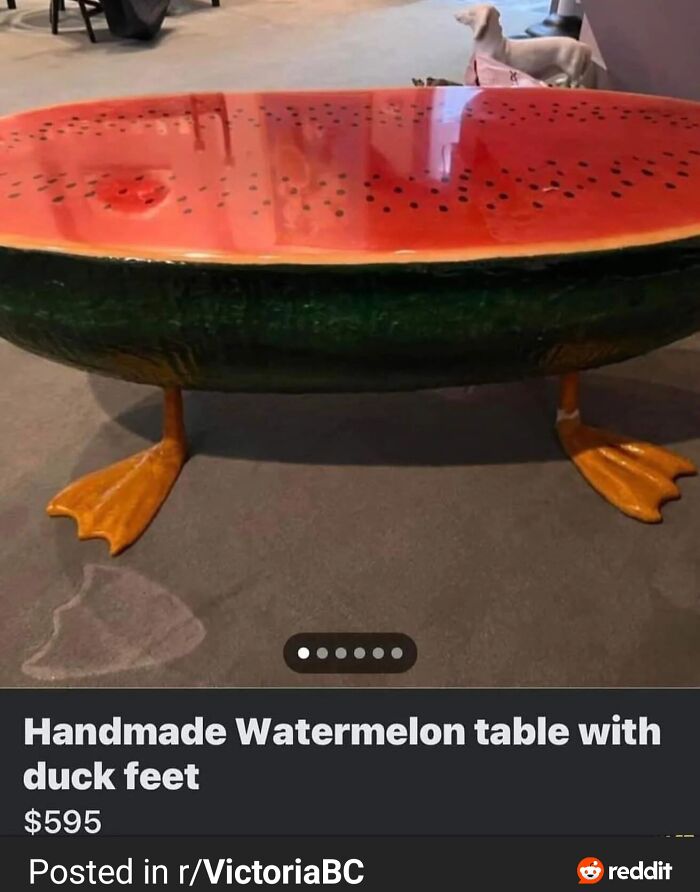 Handmade watermelon coffee table with duck feet standing on carpet in an indoor setting, unique ridiculous furniture design.