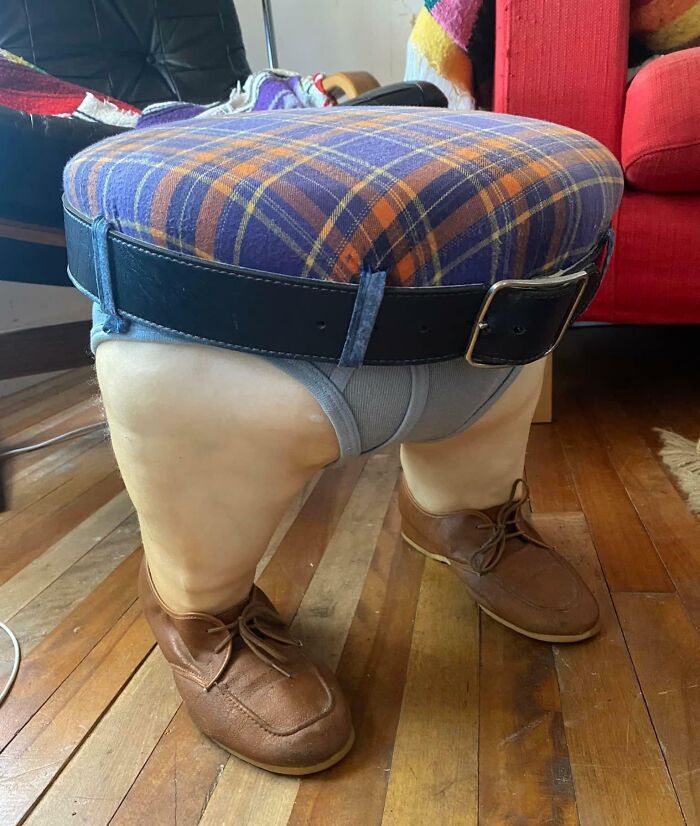 Unusual furniture stool shaped like human legs wearing shoes and a belt, showcasing a ridiculous piece of furniture design.