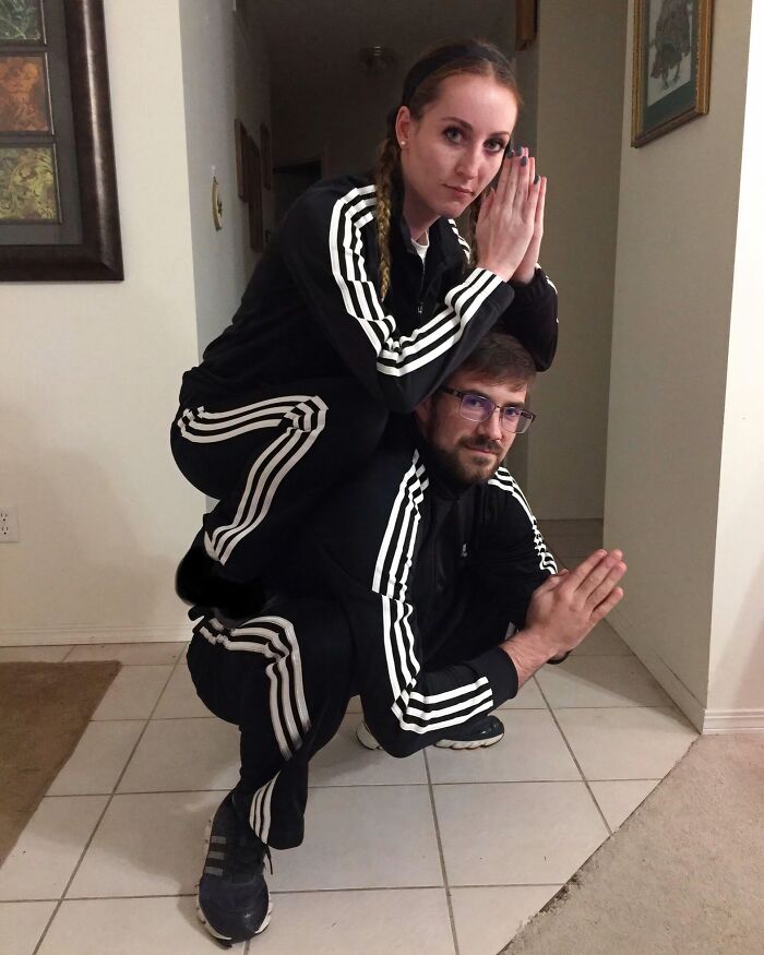 Two people in matching black tracksuits squat and pose with hands pressed together, illustrating weird subreddits popularity.