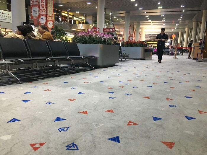 Airport waiting area with patterned carpet and people seated, illustrating a scene linked to weirdest subreddits popular online.