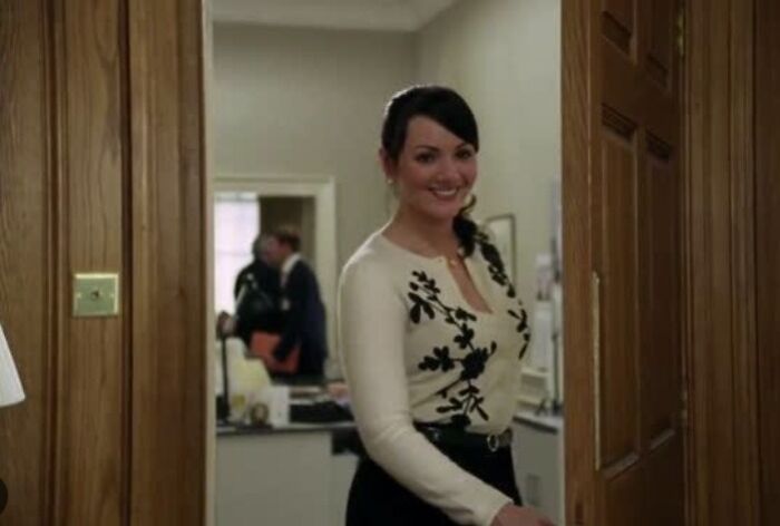 Smiling woman in a white floral top standing in a doorway, illustrating hilariously absurd movie and TV details.