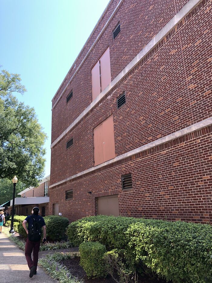 Brick building showing architectural fail with doors on upper floors leading to nowhere outdoors.