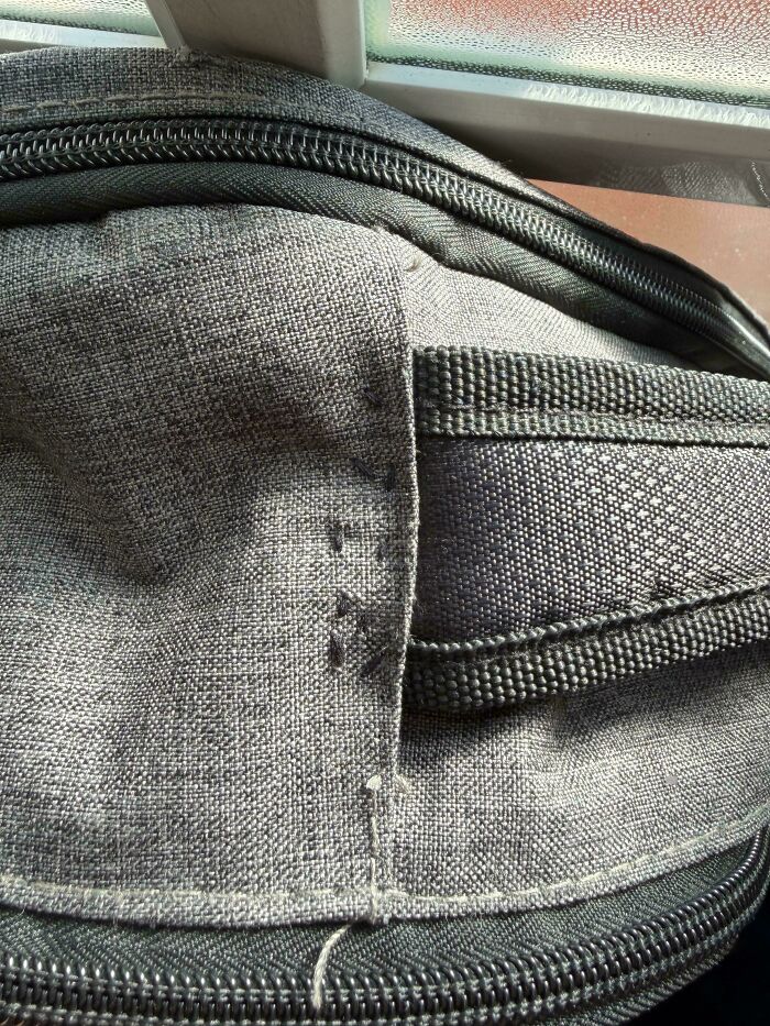 Close-up of a poorly stitched grey fabric item, showing the decline in quality and insulting consumerism.