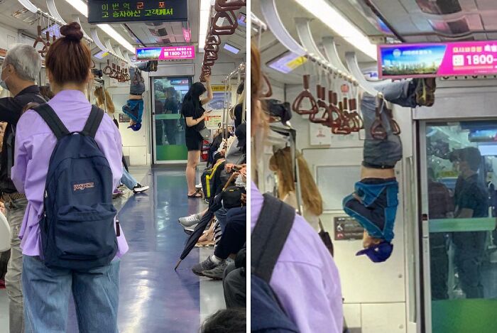 Person hanging upside down from subway handles amid seated and standing passengers on a crowded NYC subway train.
