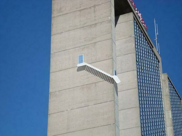 Concrete building with stairs leading to a door that opens to nowhere, showcasing architectural design failures.