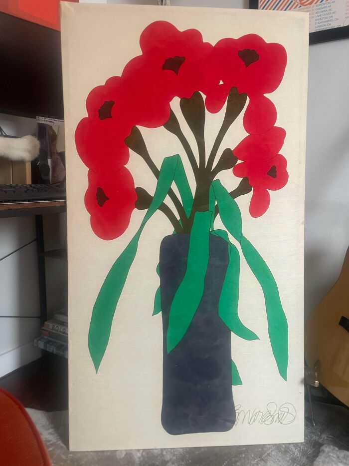 A vibrant painting of red flowers in a blue vase, a stunning thrift store jackpot.