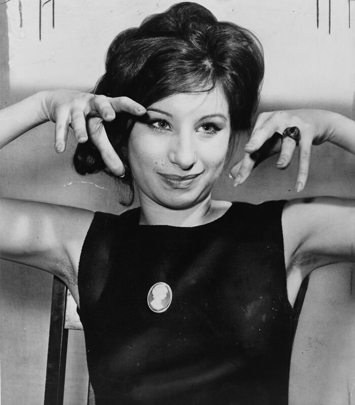 Woman posing with hands near her face, wearing a black dress and vintage ring, illustrating luxury lifestyle and custom mobile mansion.