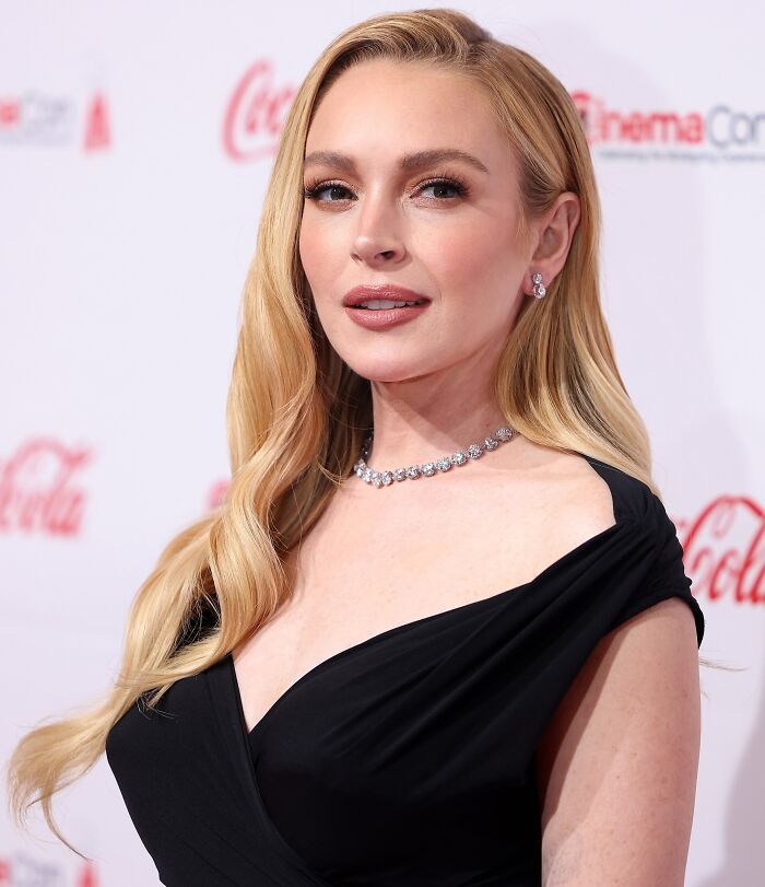 Woman in a black dress and diamond necklace at an event, representing luxury lifestyle and custom mobile mansion trends.