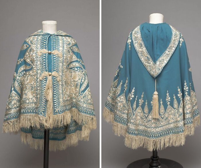 Blue and cream embroidered historical garment with tassels and intricate detailing displayed on a mannequin front and back views
