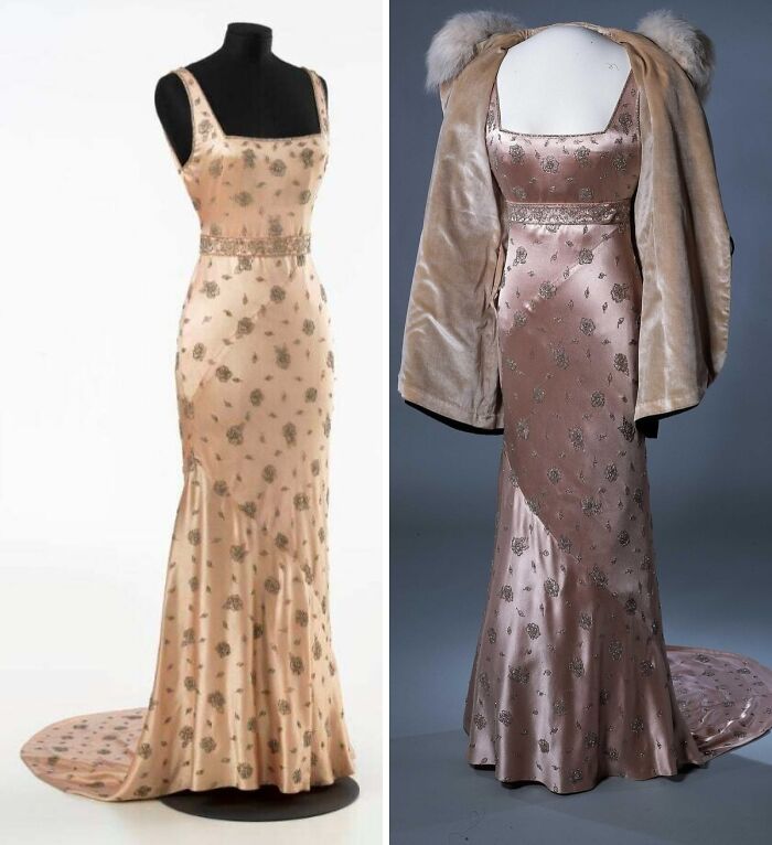 Two vintage historical garments with floral patterns displayed on mannequins, showcasing elegant silk gowns with a fur stole.