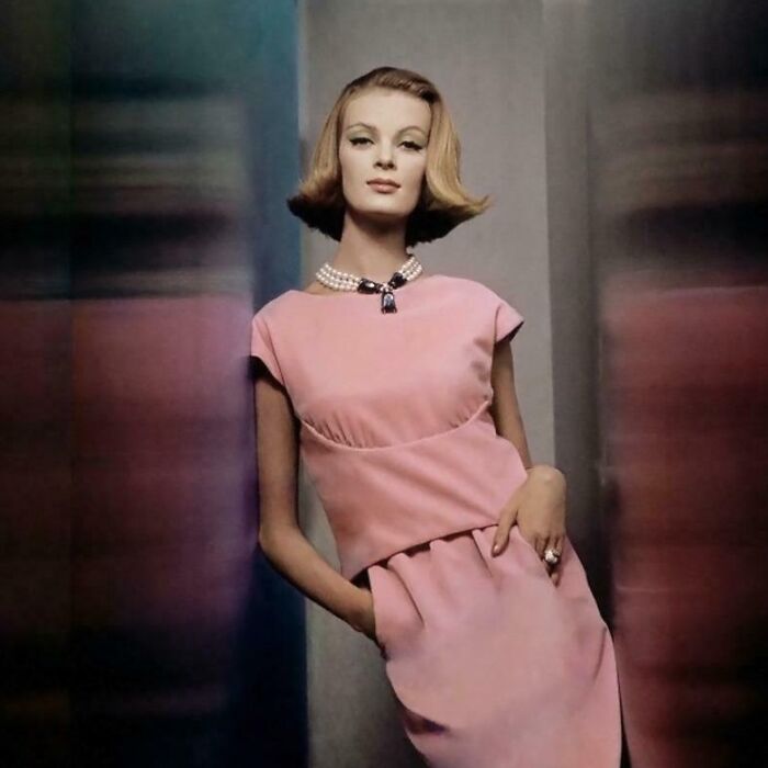 Woman in a stylish pink vintage dress and pearl necklace modeling historical garments that would break the internet today