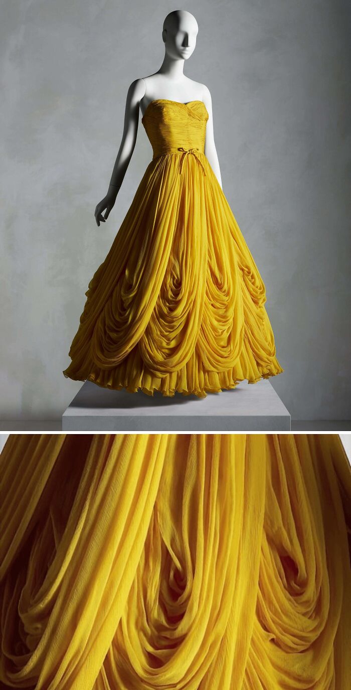 Yellow historical garment on a mannequin with intricate draped fabric and pleated details, showcasing vintage dress design.