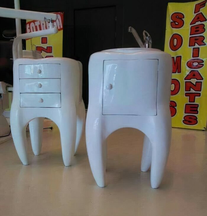 White furniture pieces designed to look like large teeth with drawers and cabinet doors in a showroom setting.