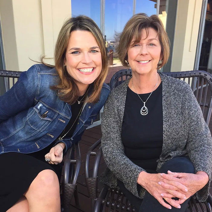Two women sitting outdoors smiling together, neighbor of Nancy Guthrie reportedly sharing crucial information.