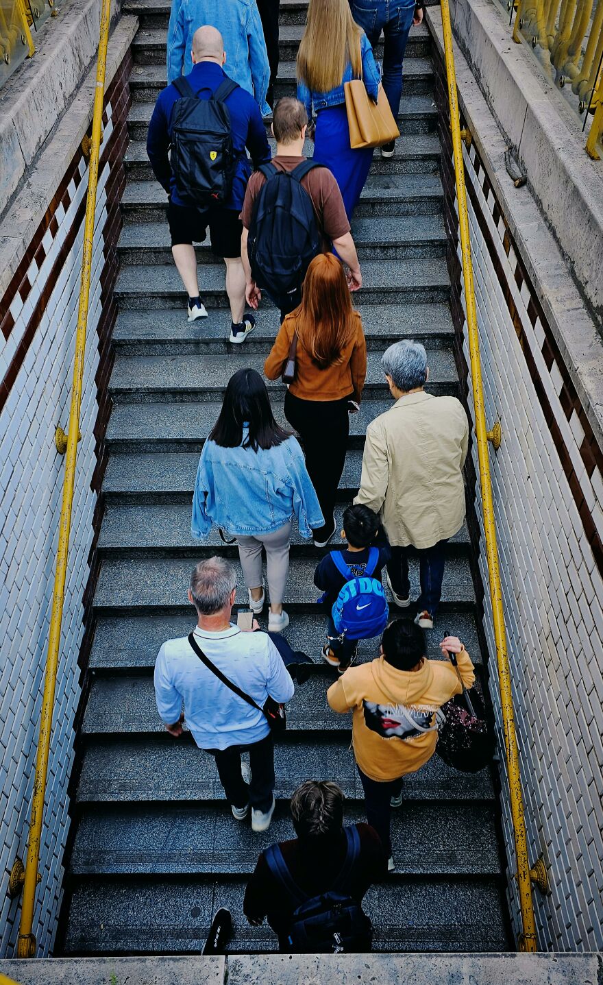 People climbing crowded stairs in a narrow passageway, illustrating common pet peeves that divide a room.