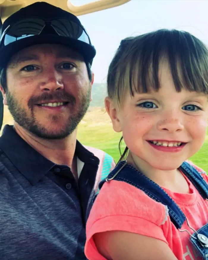 Man wearing a cap and sunglasses with a smiling young girl, capturing a moment related to Utah dance mom parent clash.